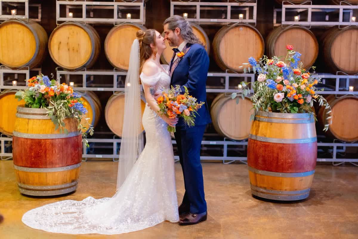 Bride and groom portrait in front of winery barrels